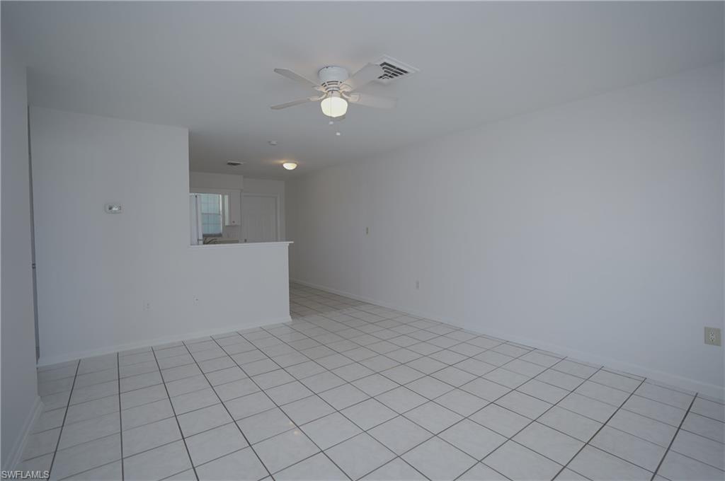 1195 South Alhambra Circle Naples, FL 34103 - Photo 5 of 34 an empty room with white walls and tiles