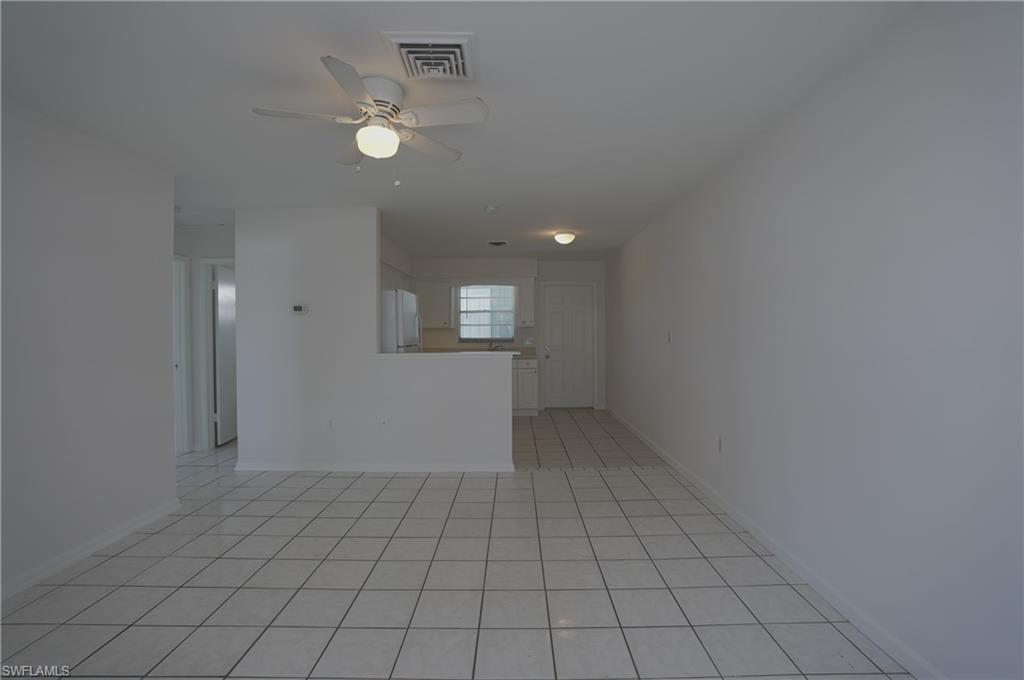 1195 South Alhambra Circle Naples, FL 34103 - Photo 7 of 34 an empty room with white walls and tiles