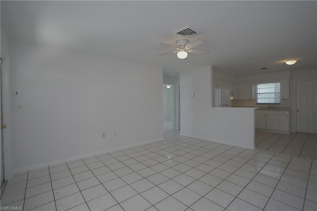 1195 South Alhambra Circle Naples, FL 34103 - Photo 8 of 34 an empty room with white walls and chandelier fan
