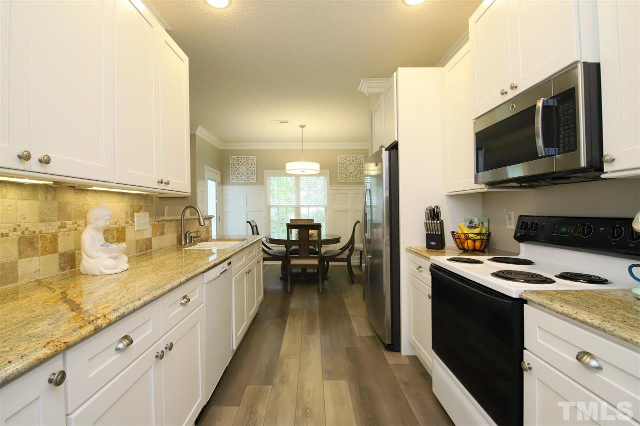2412 Pumpkin Ridge Way Raleigh, NC 27604 - Photo 13 of 30 Gorgeous kitchen with new white cabinets, granite countertops and beautiful backsplash leading into breakfast room
