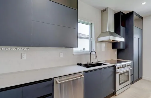 a kitchen with stainless steel appliances a sink stove and refrigerator