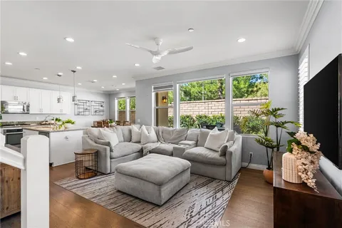 a living room with furniture kitchen and a large window