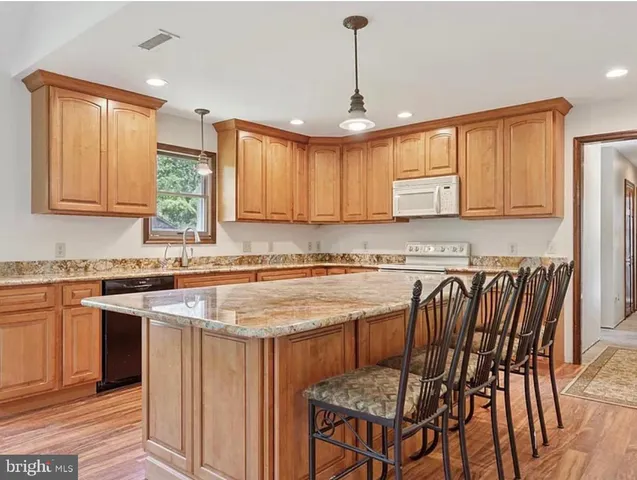 a kitchen with stainless steel appliances granite countertop a stove a sink a microwave and a refrigerator