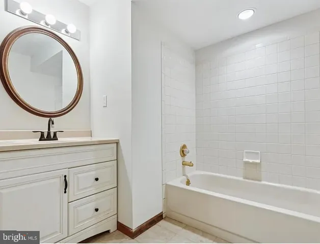 a bathroom with a bathtub a sink and a mirror