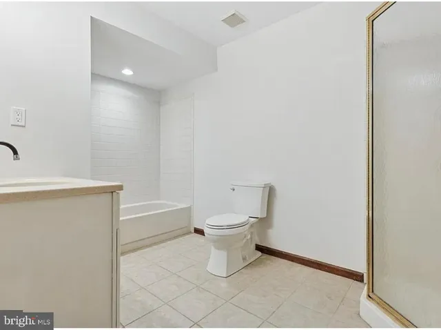 a white toilet sitting next to a shower