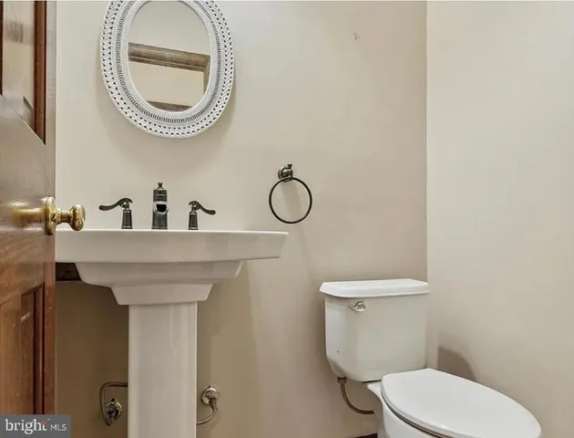 a bathroom with a toilet a sink and a mirror