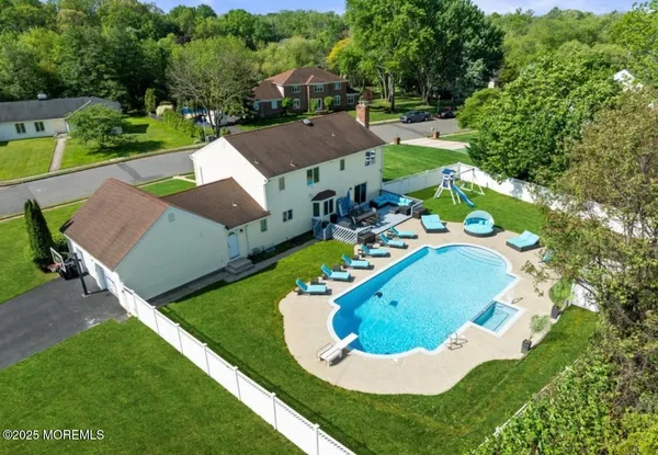 a view of a house with swimming pool and a yard
