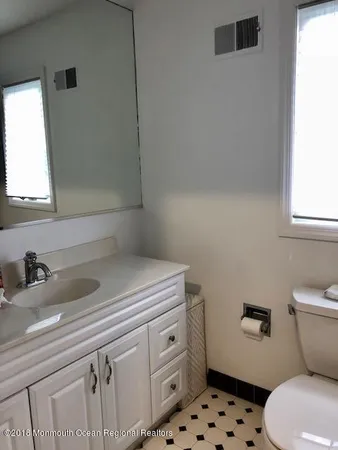 a bathroom with a sink toilet and window