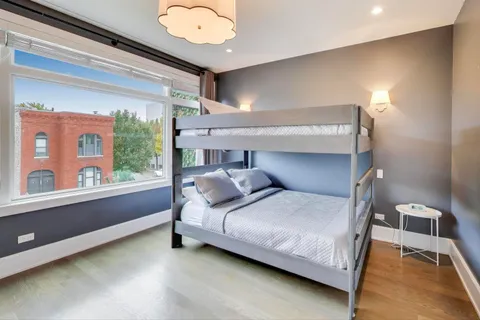 a kitchen with stainless steel appliances granite countertop a stove a sink a refrigerator with wooden cabinets and wooden floor