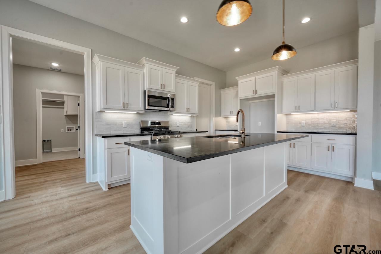 636 Prince Lane Tyler, TX 75704 - Photo 7 of 38 a kitchen with kitchen island granite countertop a sink and refrigerator