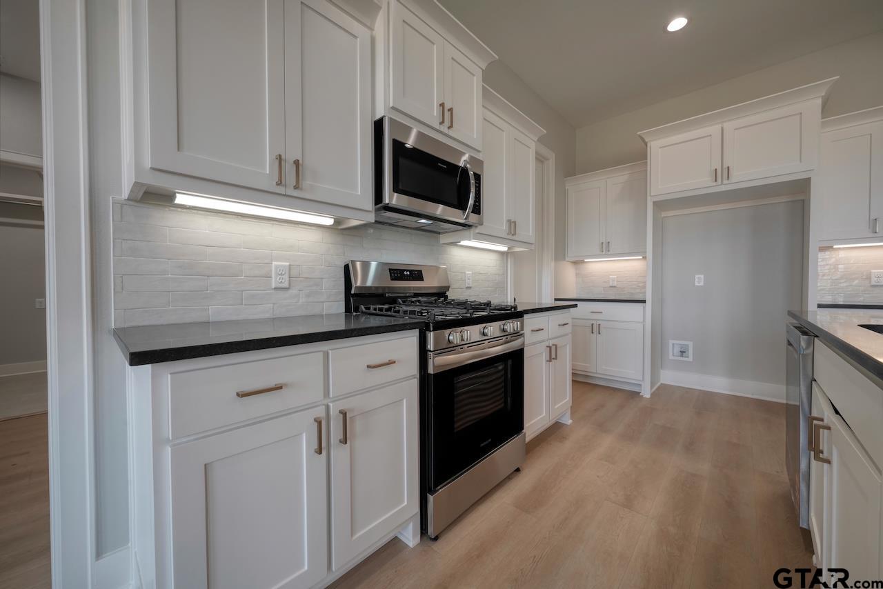 636 Prince Lane Tyler, TX 75704 - Photo 9 of 38 a kitchen with white cabinets and appliances