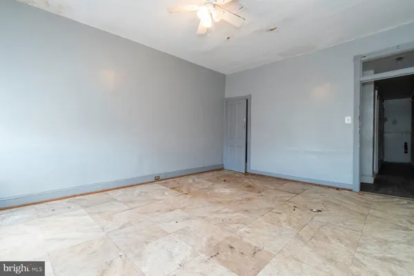 a view of an empty room with a chandelier fan