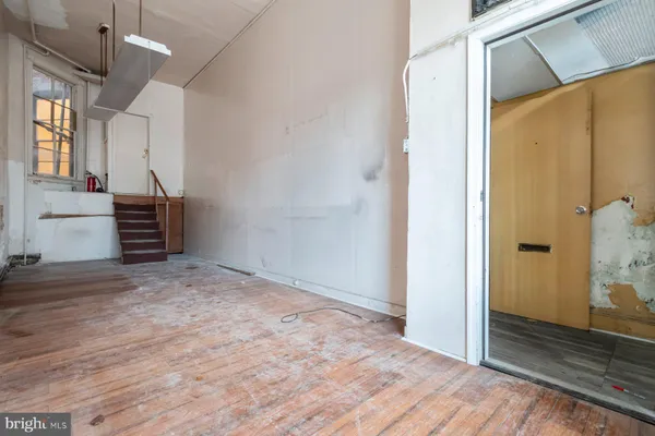 a view of a livingroom with wooden floor and a window