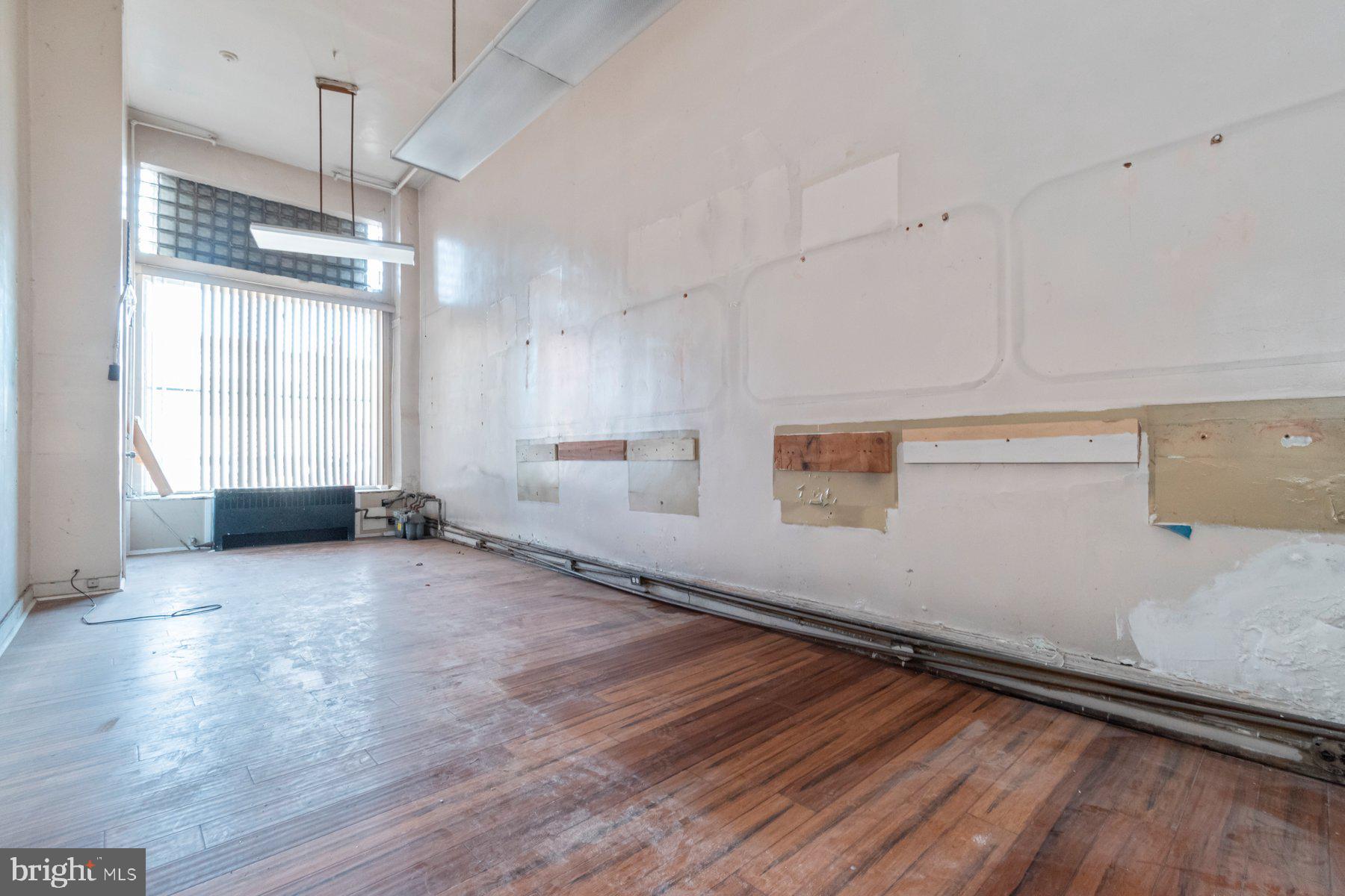 2273 Reisterstown Road Baltimore, MD 21217 - Photo 8 of 27 an empty room with wooden floor and windows