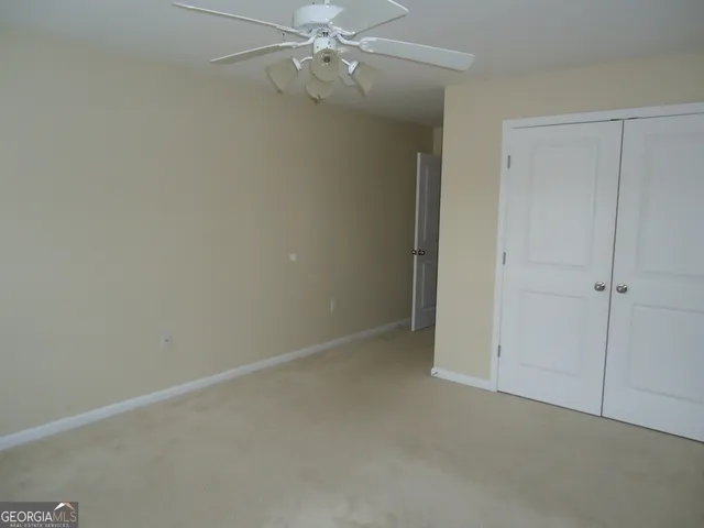 an empty room with a chandelier fan