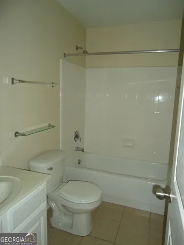 a white toilet sitting next to a bath tub