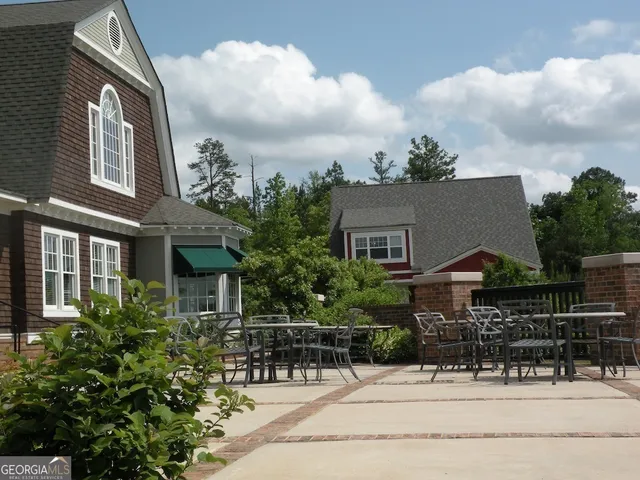 a view of house with yard and sitting area