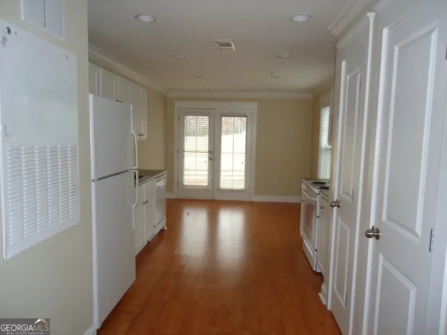 a view of a hallway with wooden floor and staircase