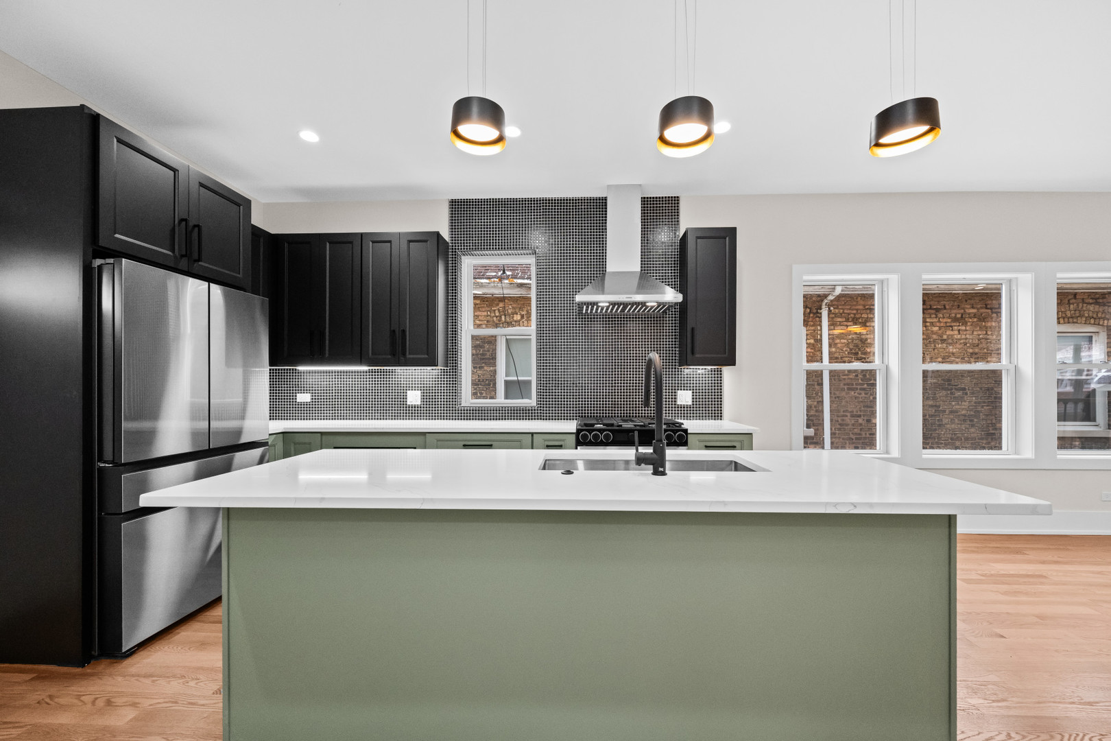 7827 South Merrill Avenue Chicago, IL 60649 - Photo 14 of 42 a kitchen with kitchen island a counter space a sink and stainless steel appliances