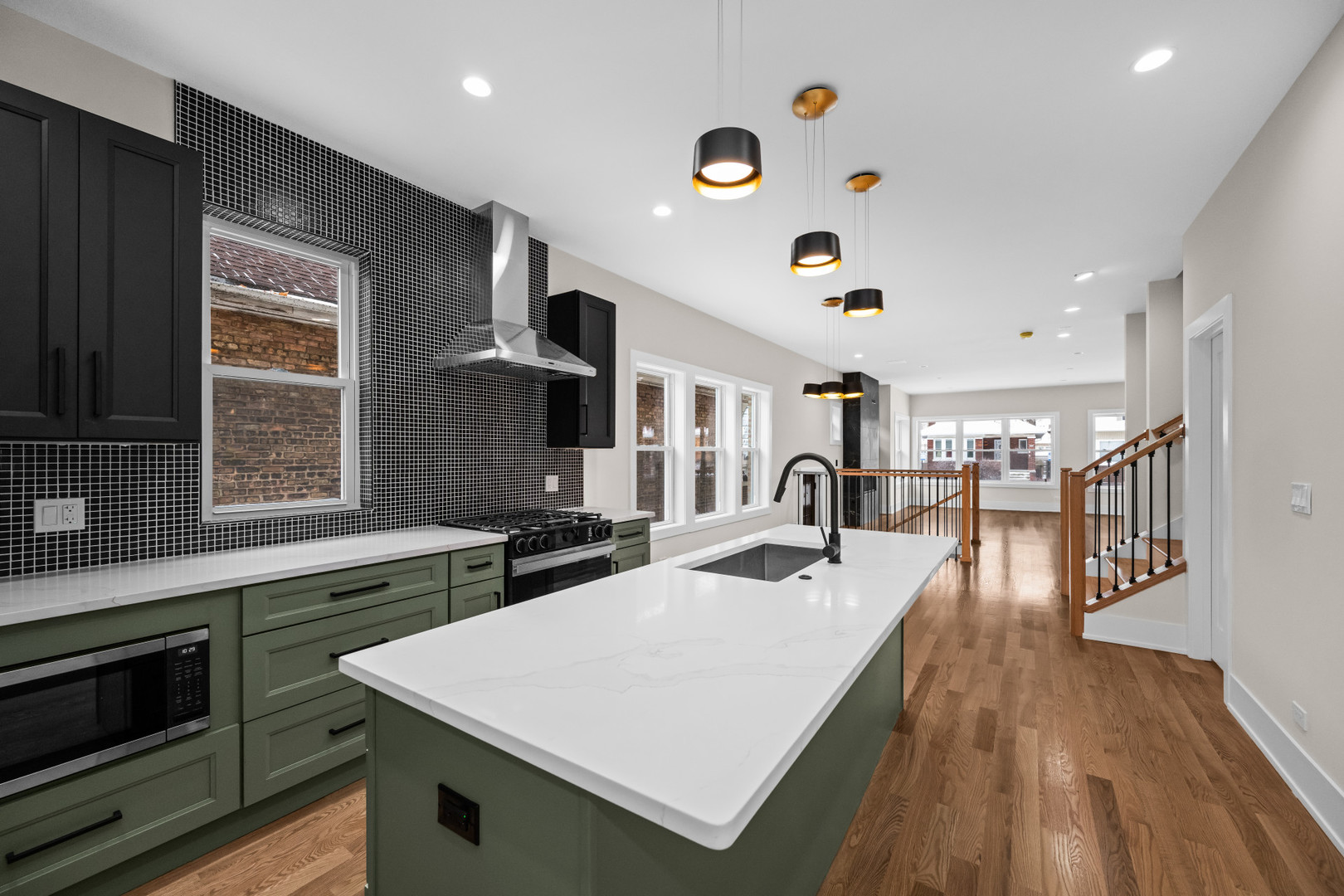 7827 South Merrill Avenue Chicago, IL 60649 - Photo 15 of 42 a large kitchen with stainless steel appliances granite countertop a stove and a wooden floors