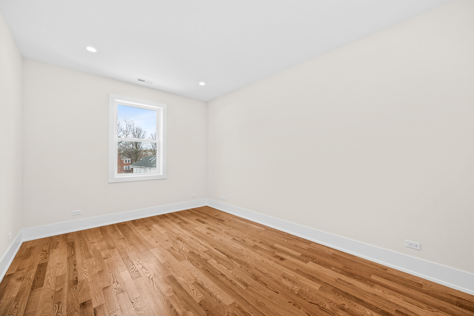 7827 South Merrill Avenue Chicago, IL 60649 - Photo 19 of 42 an empty room with wooden floor and windows