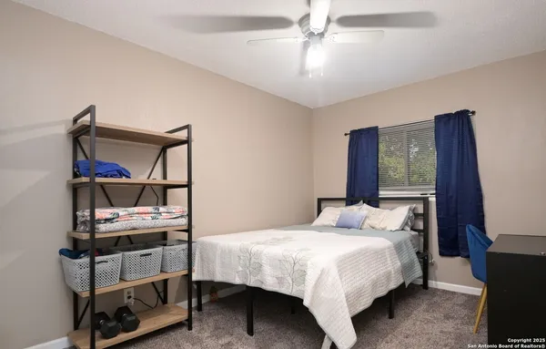 a bedroom with a bed a chandelier and a window