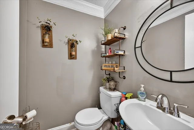 a bathroom with a toilet sink mirror and vanity