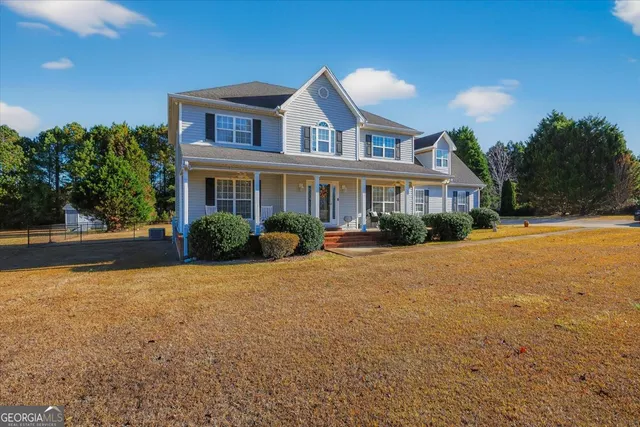 a front view of a house with a yard and potted plants