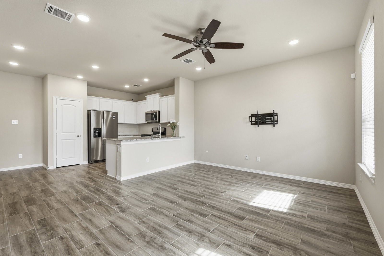 8038 Scanlan Trace Missouri City, TX 77459 - Photo 4 of 25 a view of a kitchen with wooden floor and a ceiling fan