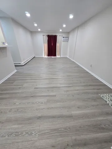 a view of an empty room with wooden floor