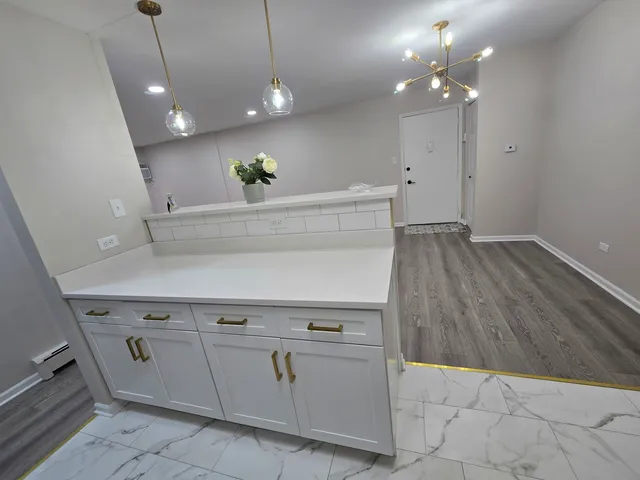 a view of a kitchen with a sink and chandelier
