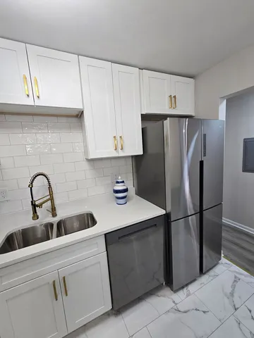 a kitchen with stainless steel appliances a white stove top oven a refrigerator a sink and dishwasher