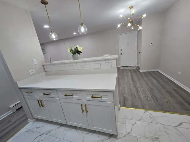 a view of a kitchen with a sink and chandelier