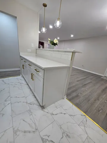 a view of a kitchen with a sink and chandelier