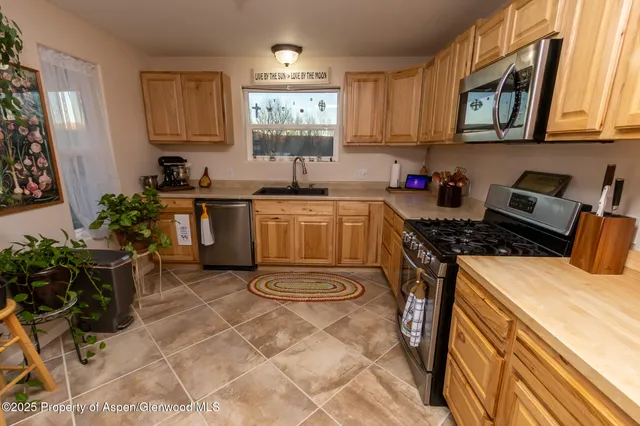 a kitchen with stainless steel appliances granite countertop a sink stove and microwave