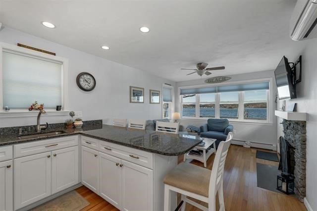 144 Lake Street, Unit 11 Laconia, NH 03246 - Photo 13 of 38 a open kitchen with a sink and a stove top oven with wooden floor