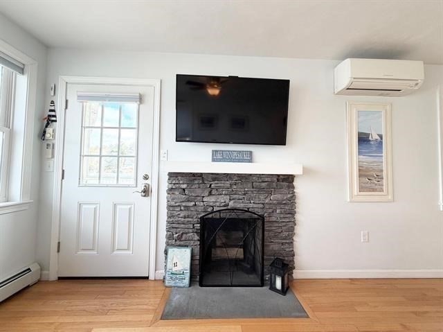 144 Lake Street, Unit 11 Laconia, NH 03246 - Photo 17 of 38 a living room with a fireplace and a flat screen tv