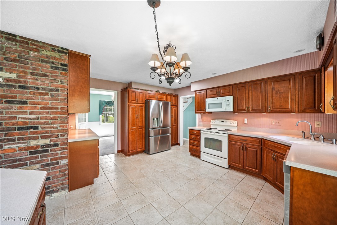 3325 Frantz Road Medina, OH 44256 - Photo 8 of 40 Kitchen featuring light countertops, wooden cabinets, white appliances, and a chandelier