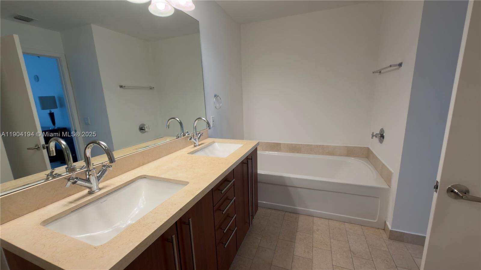 1111 Southwest 1st Avenue, Unit 2516N Miami, FL 33130 - Photo 20 of 31 a bathroom with a sink vanity tub and a mirror