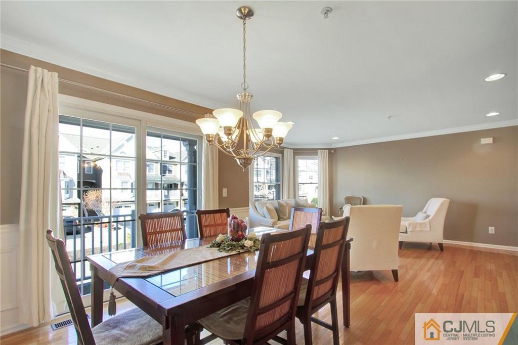 21 Raritan Reach Road, Unit 11 South Amboy, NJ 08879 - Photo 7 of 28 a view of a dining room with furniture a chandelier and wooden floor