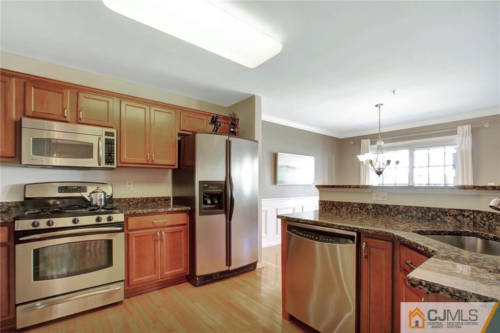 21 Raritan Reach Road, Unit 11 South Amboy, NJ 08879 - Photo 8 of 28 a kitchen with granite countertop a refrigerator stove and sink