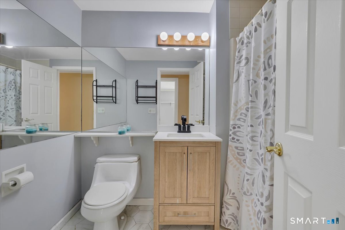 565 Talcottville Road, Unit 1A1 Vernon, CT 06066 - Photo 15 of 27 a bathroom with a toilet sink and mirror