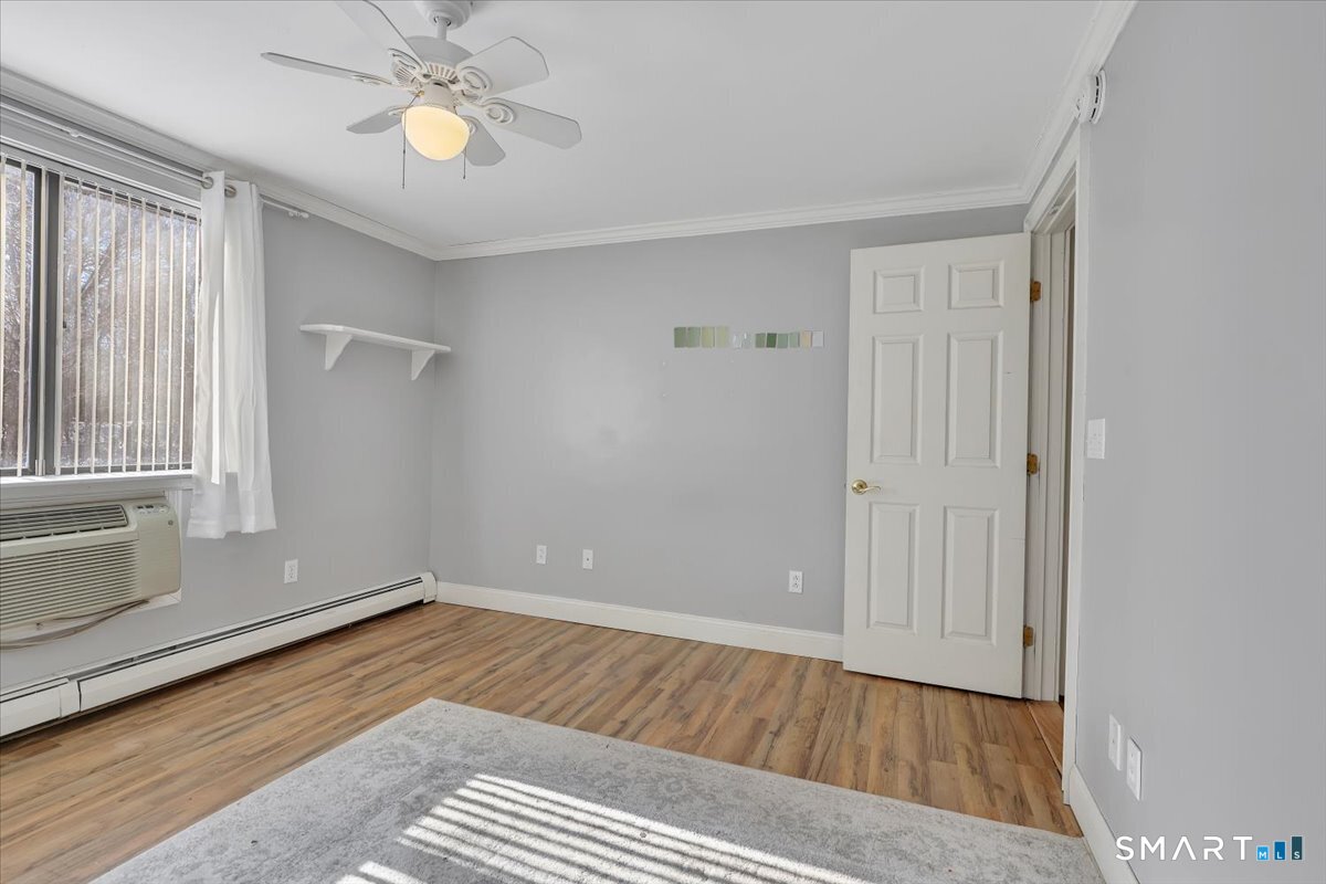 565 Talcottville Road, Unit 1A1 Vernon, CT 06066 - Photo 17 of 27 a view of an empty room with a window and wooden floor