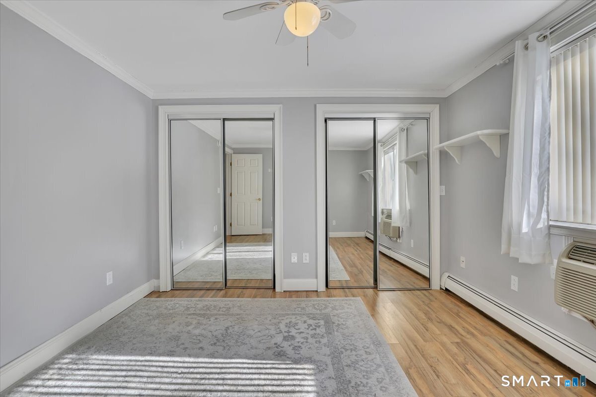 565 Talcottville Road, Unit 1A1 Vernon, CT 06066 - Photo 18 of 27 a view of an empty room with wooden floor and a window