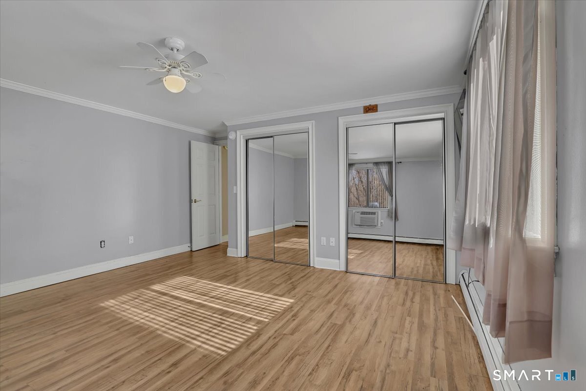 565 Talcottville Road, Unit 1A1 Vernon, CT 06066 - Photo 21 of 27 a view of an empty room with wooden floor and a window