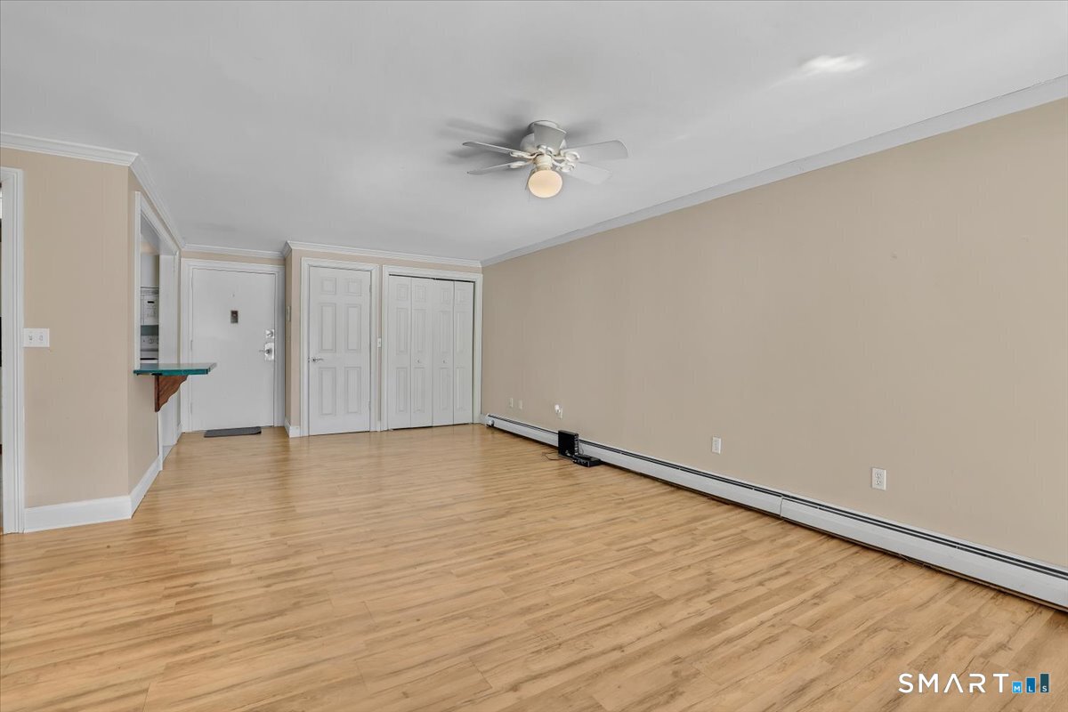 565 Talcottville Road, Unit 1A1 Vernon, CT 06066 - Photo 3 of 27 a view of an empty room with wooden floor and a ceiling fan