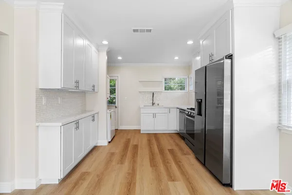 a kitchen with white cabinets and stainless steel appliances