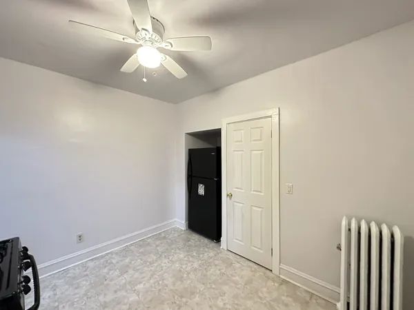 an empty room with closet and a chandelier fan