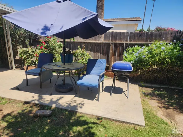 a view of a patio with table and chairs potted plants