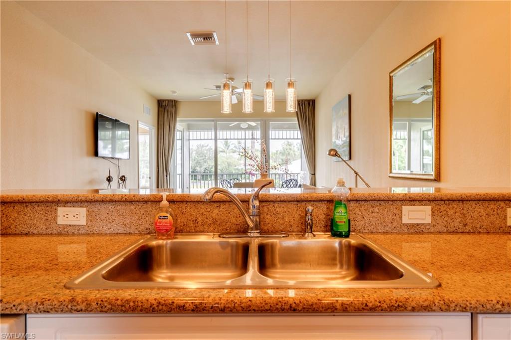 7930 Mahogany Run Lane, Unit 824 Naples, FL 34113 - Photo 12 of 40 a kitchen with granite countertop a sink and a wooden floor